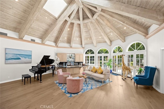 sitting room featuring beam ceiling, light hardwood / wood-style floors, and french doors