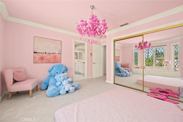 carpeted bedroom with connected bathroom, a closet, ornamental molding, and a notable chandelier