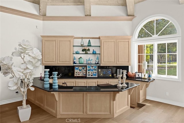 kitchen featuring kitchen peninsula, beam ceiling, light wood-type flooring, and light brown cabinetry