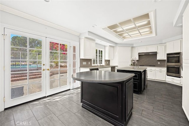 kitchen featuring french doors, double oven, a kitchen island, and plenty of natural light