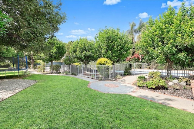 surrounding community with a lawn and a trampoline