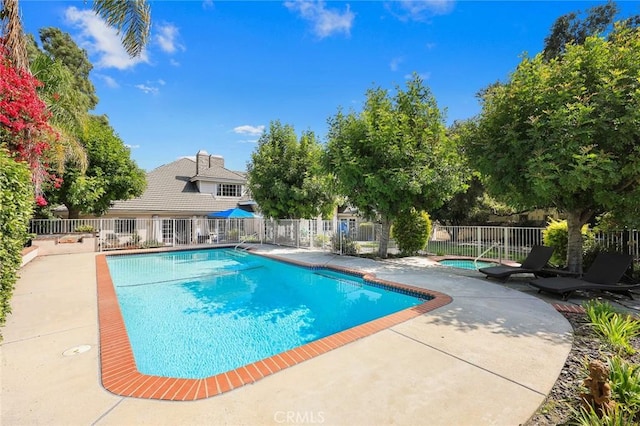 view of pool featuring a patio area and an in ground hot tub