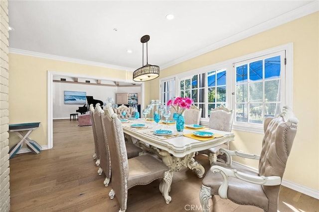 dining space featuring wood-type flooring and crown molding