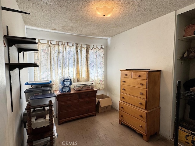 bedroom with a textured ceiling and wood-type flooring