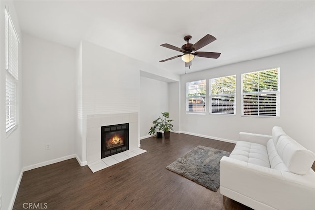 living room featuring ceiling fan, a fireplace, and dark hardwood / wood-style flooring