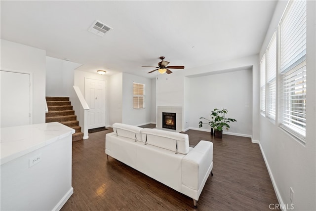 living room featuring ceiling fan and dark wood-type flooring