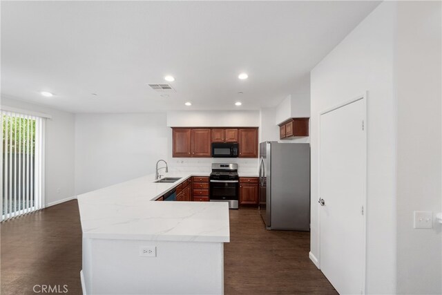 kitchen with stainless steel appliances, kitchen peninsula, dark wood-type flooring, and sink