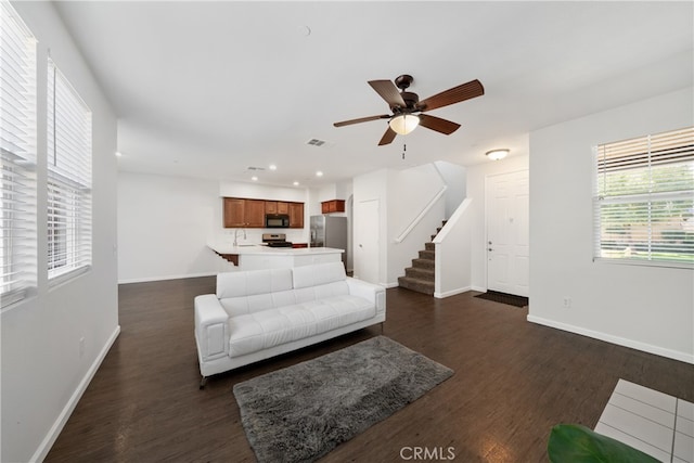 living room with ceiling fan, dark hardwood / wood-style floors, and sink