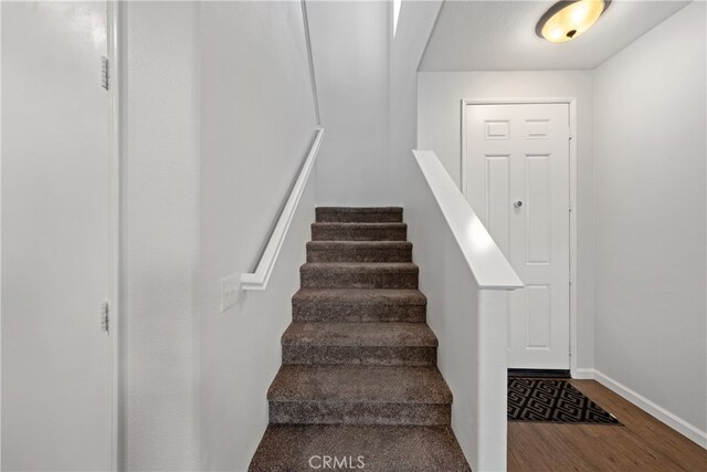 stairway featuring wood-type flooring