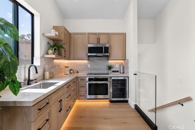 kitchen with beverage cooler, stainless steel appliances, tasteful backsplash, light hardwood / wood-style floors, and sink