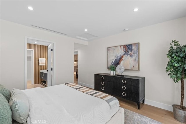 bedroom with light hardwood / wood-style floors and ensuite bath