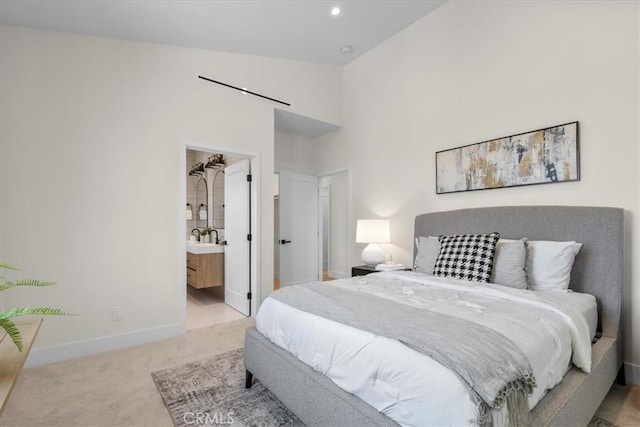 carpeted bedroom with high vaulted ceiling and connected bathroom