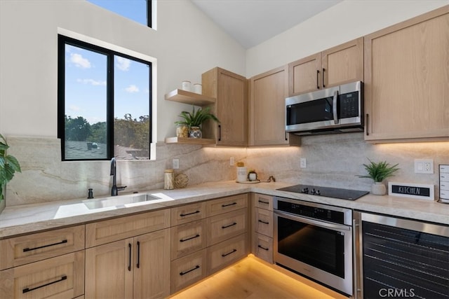 kitchen featuring sink, light brown cabinetry, appliances with stainless steel finishes, and decorative backsplash