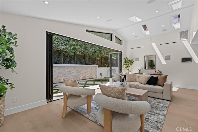 living room with plenty of natural light, light hardwood / wood-style flooring, and vaulted ceiling