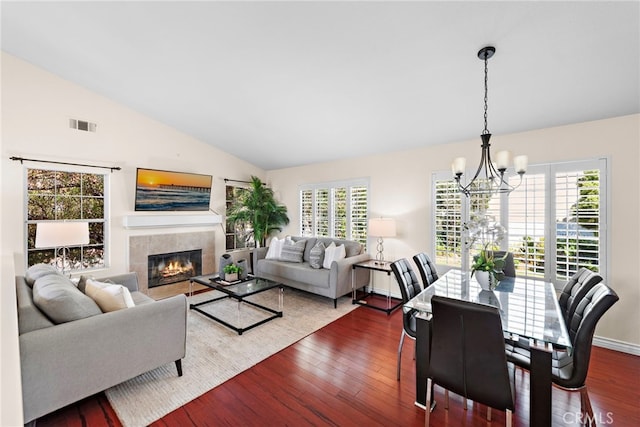 dining space featuring a fireplace, dark hardwood / wood-style floors, plenty of natural light, and a chandelier