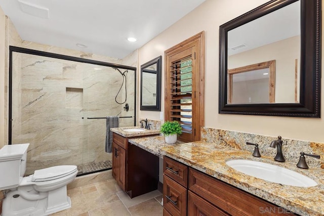 bathroom featuring an enclosed shower, vanity, and toilet