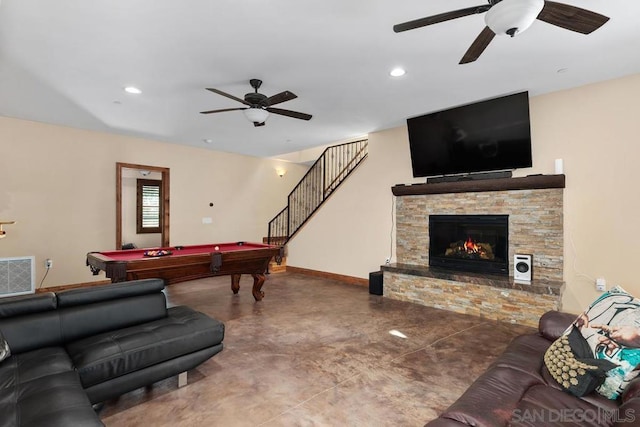 living room featuring concrete flooring, a fireplace, pool table, and ceiling fan