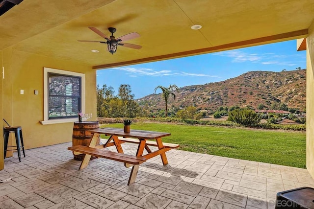 view of patio / terrace with ceiling fan and a mountain view