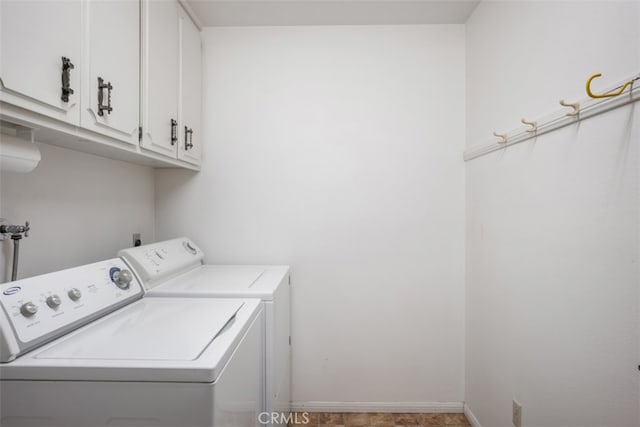 washroom featuring washing machine and clothes dryer and cabinets