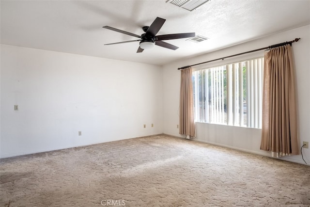 empty room featuring ceiling fan, a textured ceiling, and carpet flooring