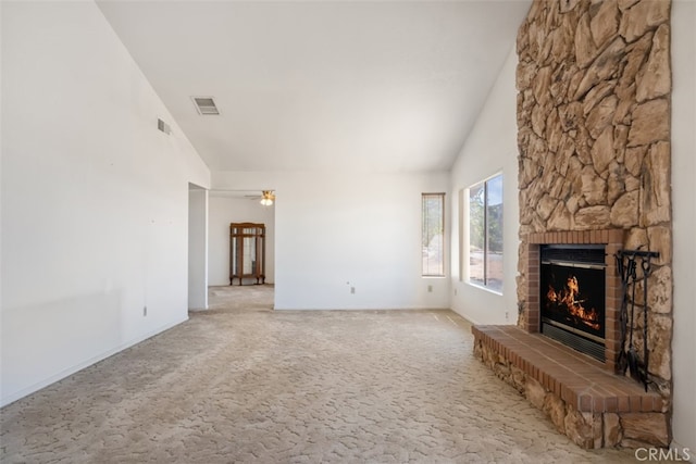 unfurnished living room featuring a fireplace, vaulted ceiling, and carpet