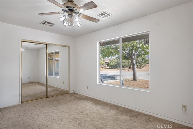 unfurnished bedroom featuring carpet, ceiling fan, and a closet