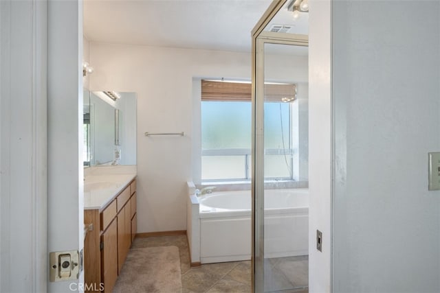 bathroom with vanity, a bath, and tile patterned floors