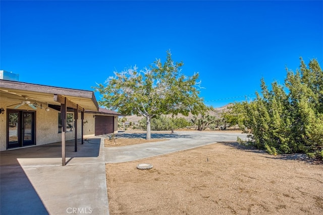 view of yard with a patio and ceiling fan