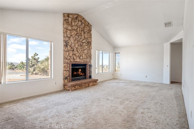 unfurnished living room featuring lofted ceiling, a fireplace, and carpet flooring