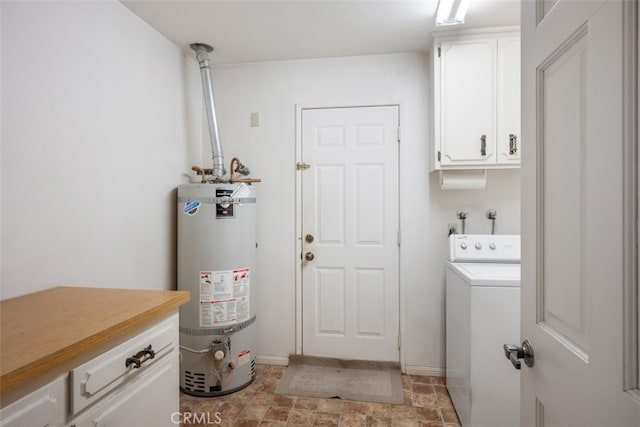 clothes washing area with strapped water heater, washer / dryer, and cabinets