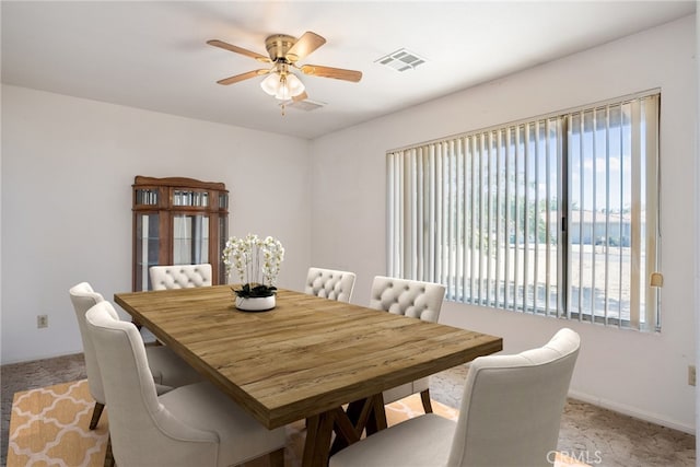 carpeted dining space with ceiling fan and a water view