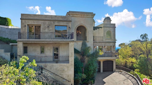 view of front facade featuring a balcony and a garage