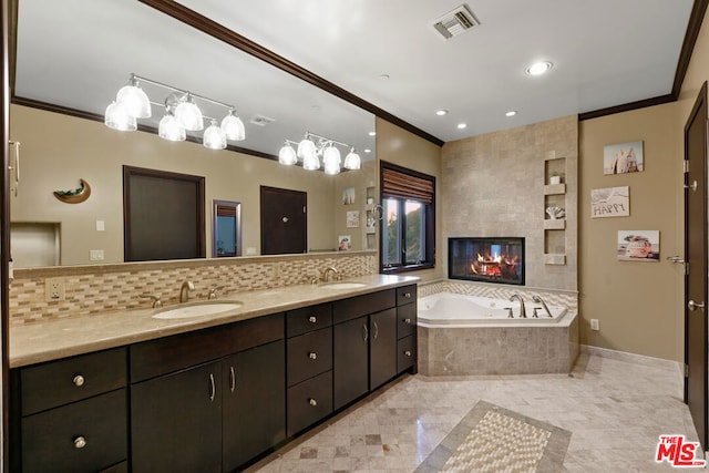 bathroom with vanity, a relaxing tiled tub, and ornamental molding