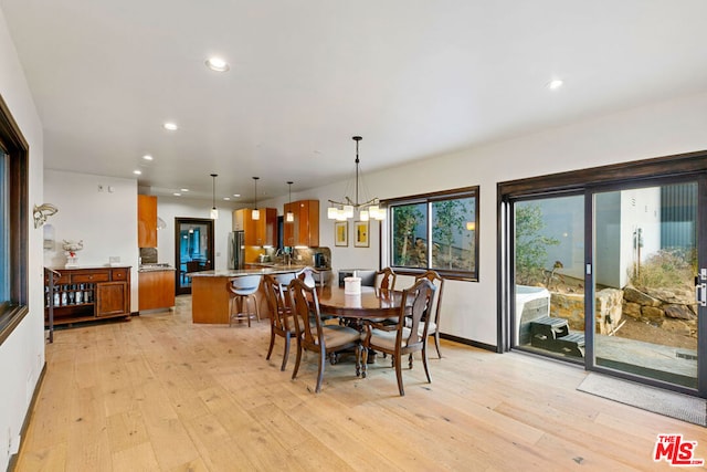 dining area featuring light wood-type flooring and a notable chandelier