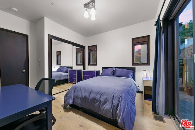 bedroom with a chandelier and light hardwood / wood-style floors