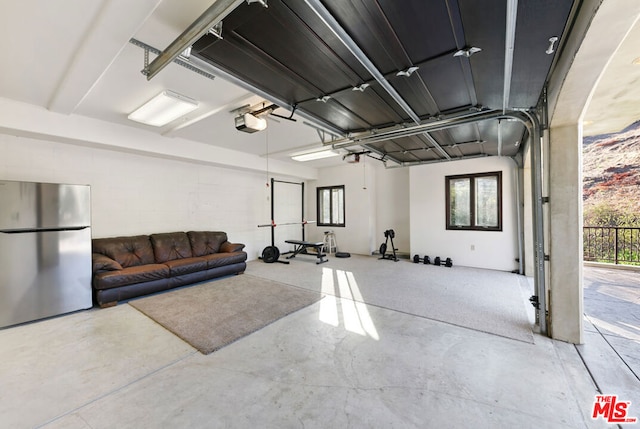 garage featuring a garage door opener and stainless steel refrigerator