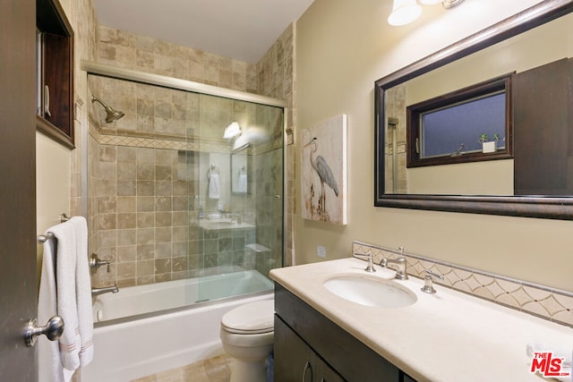 full bathroom featuring toilet, enclosed tub / shower combo, and vanity