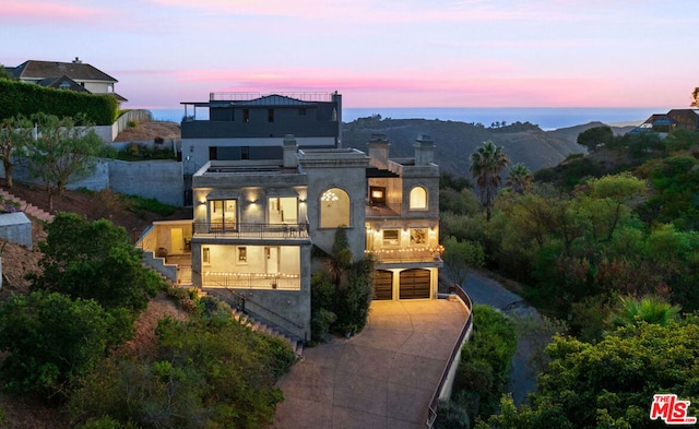 view of front of property featuring a balcony and a garage