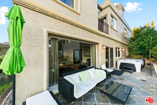 view of patio with a hot tub and an outdoor living space