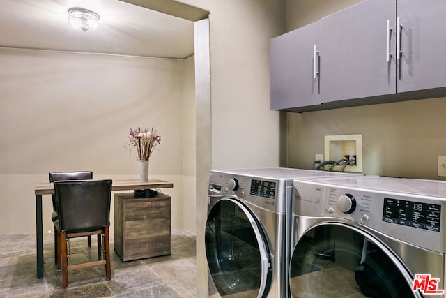 laundry room featuring washer and clothes dryer and cabinets