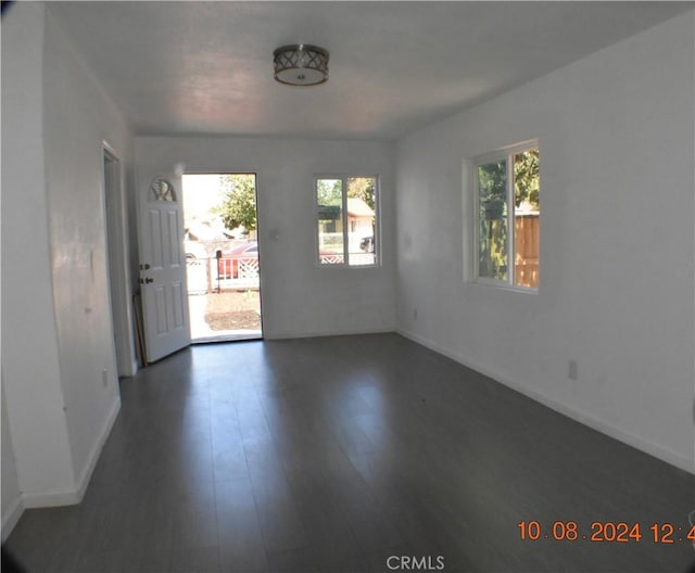 unfurnished room with dark wood-type flooring