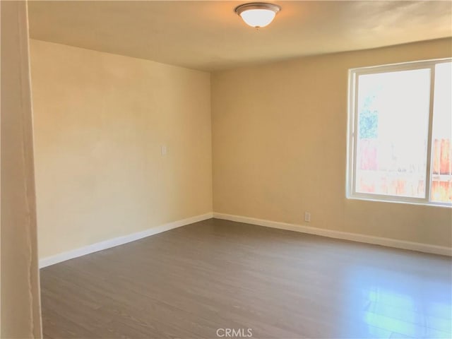 empty room with dark hardwood / wood-style flooring