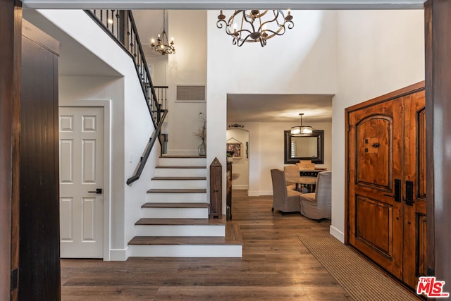 entryway with a towering ceiling and dark hardwood / wood-style flooring