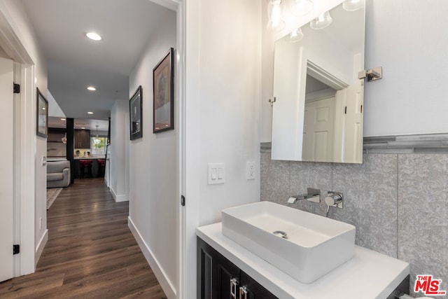 bathroom with tasteful backsplash, hardwood / wood-style floors, and vanity