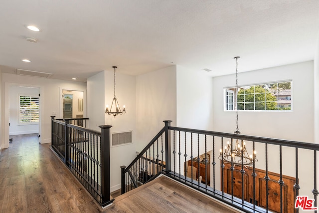 hallway with dark hardwood / wood-style flooring and a chandelier