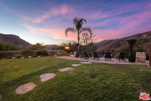 yard at dusk with a mountain view and a patio