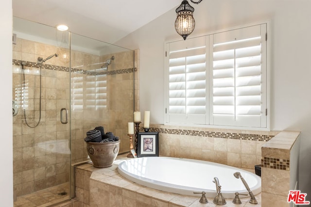 bathroom featuring shower with separate bathtub