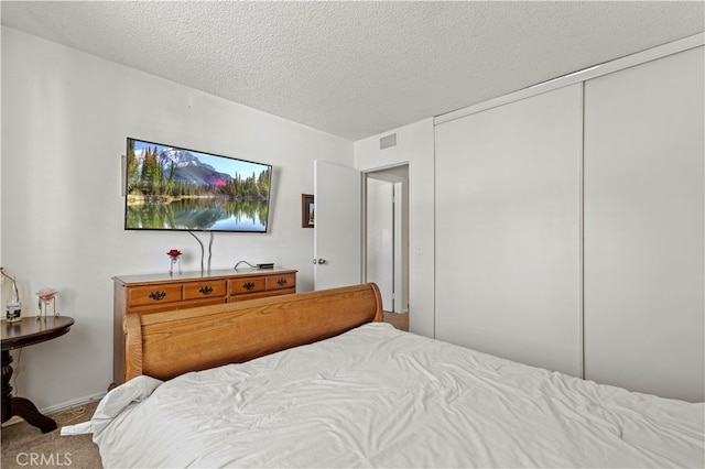 bedroom featuring a textured ceiling and a closet