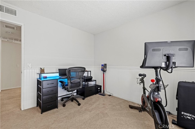 carpeted office featuring a textured ceiling