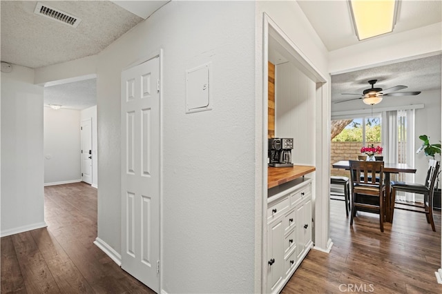 hallway featuring a textured ceiling and dark hardwood / wood-style flooring